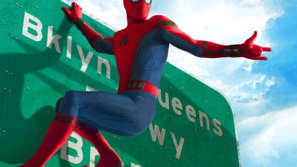 Spider-Man hanging from a highway sign.