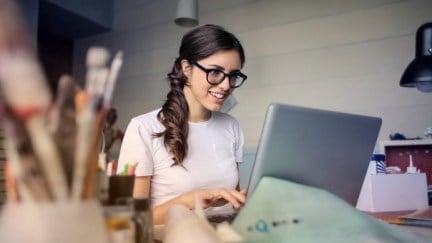 woman enthusiastically looking at laptop screen