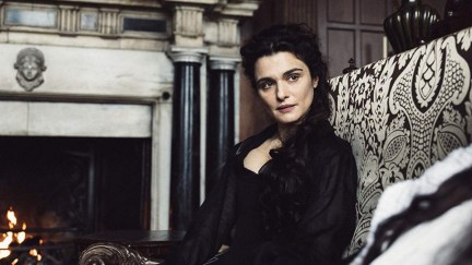 Rachel Weisz sitting on a couch with a stern look in 