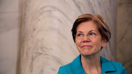 Elizabeth Warren stands against a marble wall looking charming and presidential.