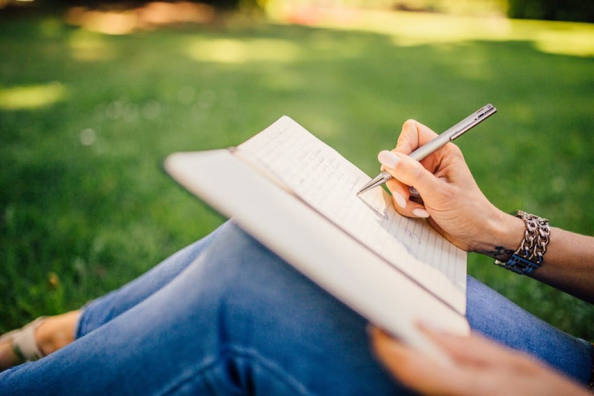 Person writing in a notebook.