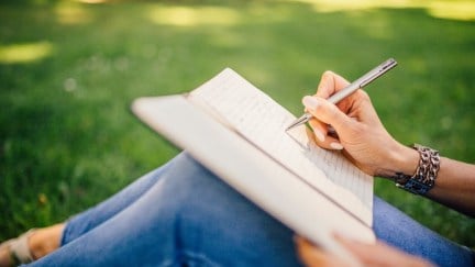 Person writing in a notebook.