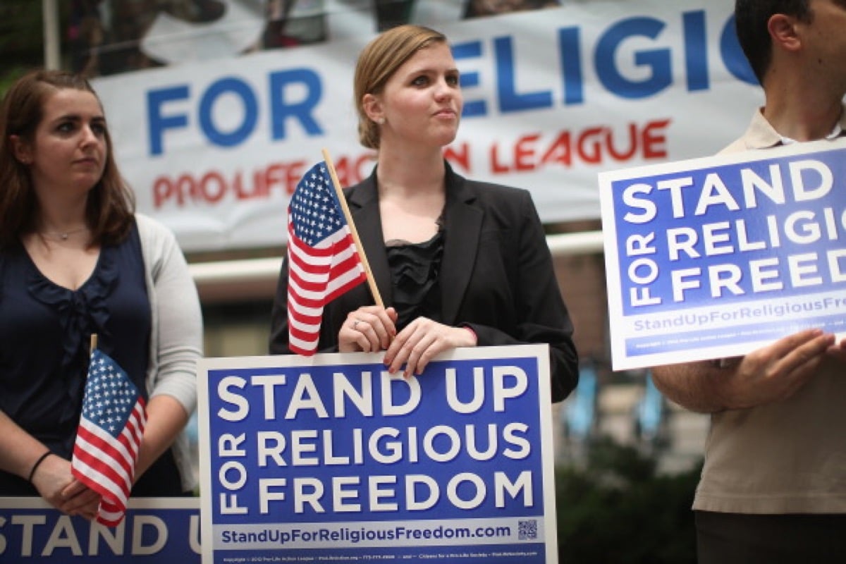 Religious freedom protesters with signs and American flags.