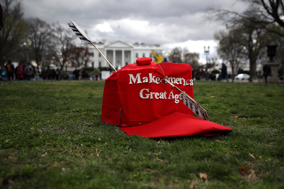 An oversized replica of a 'Make America Great Again' hat sits on the grass across from the White House during a demonstration against the Dakota Access Pipeline