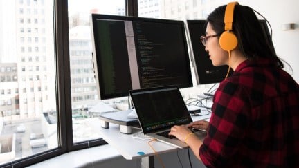 Person coding on computers.