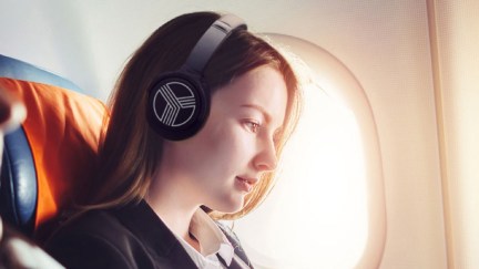 A woman listening to headphones on an airplane.