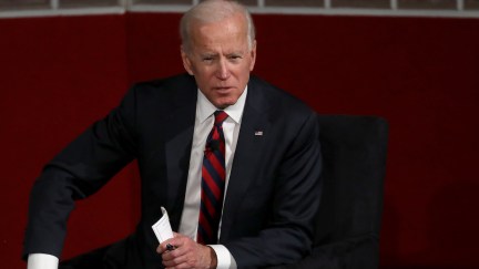 Joe Biden seated, leaning forward and speaking.