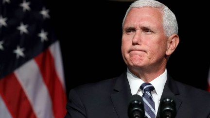 Mike Pence looks unhappy in front of the American flag.