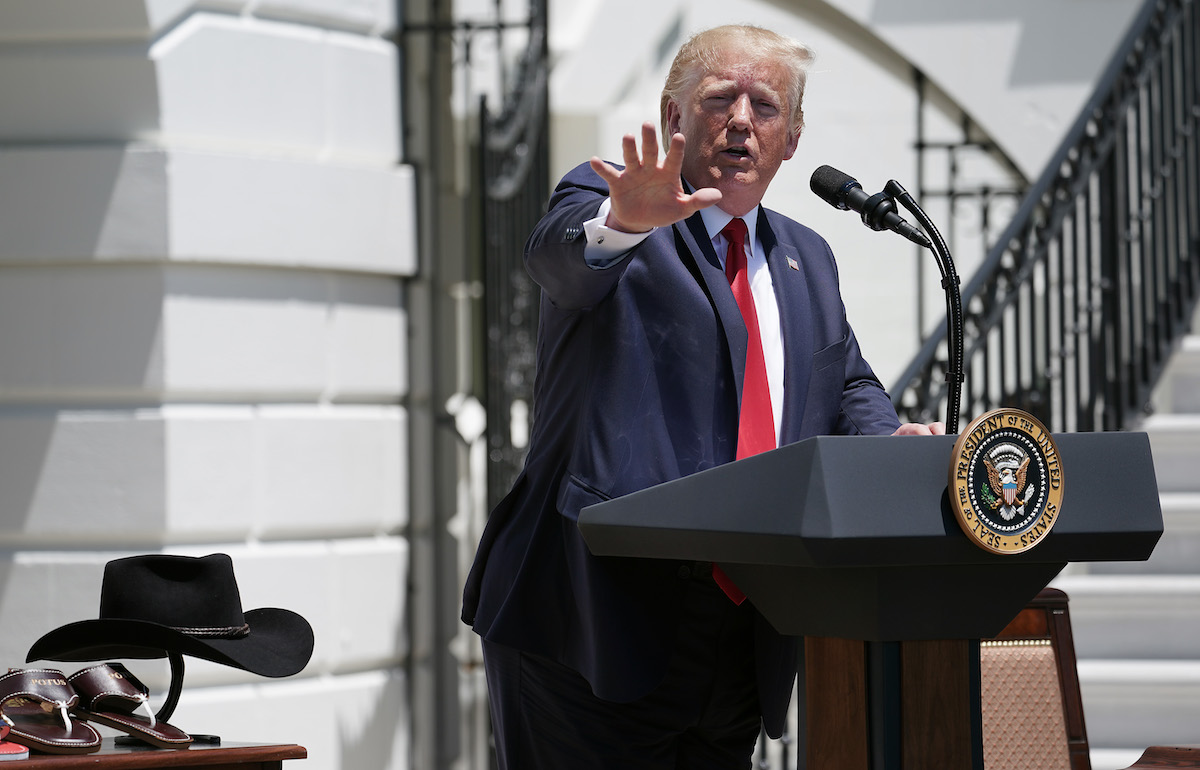 Donald Trump holds his hand up, as if to stop us from calling him out on his racism.