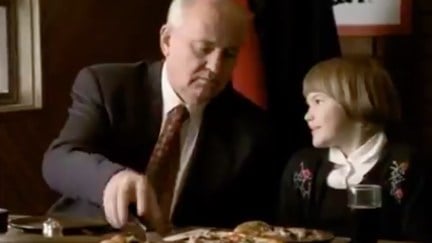 Gorbachev inexplicably eats Pizza Hut pizza with a happy child.