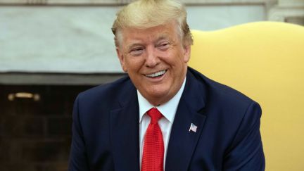 Donald Trump smirks with his orange face.