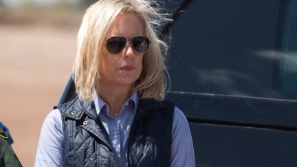 Secretary of Homeland Security Kirstjen Nielsen waits for US President Donald Trump as he arrives to tour the border wall.