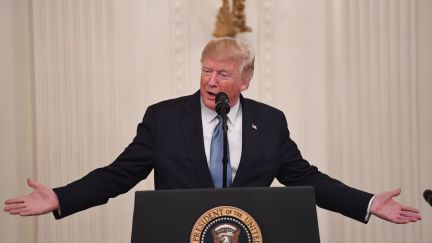 Donald Trump speaks at a podium.