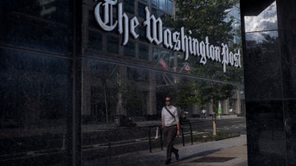 A man walks past The Washington Post on August 5, 2013 in Washington, DC after it was announced that Amazon.com founder and CEO Jeff Bezos had agreed to purchase the Post for USD 250 million. Multi-billionaire Bezos, who created Amazon, which has soared in a few years to a dominant position in online retailing, said he was buying the Post in his personal capacity and hoped to shepherd it through the evolution away from traditional newsprint. AFP PHOTO/Brendan SMIALOWSKI (Photo credit should read BRENDAN SMIALOWSKI/AFP via Getty Images)