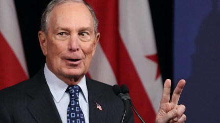 Michael Bloomberg holds up two fingers for the number of hundreds of millions of dollars he's spent on his presidential campaign so far.