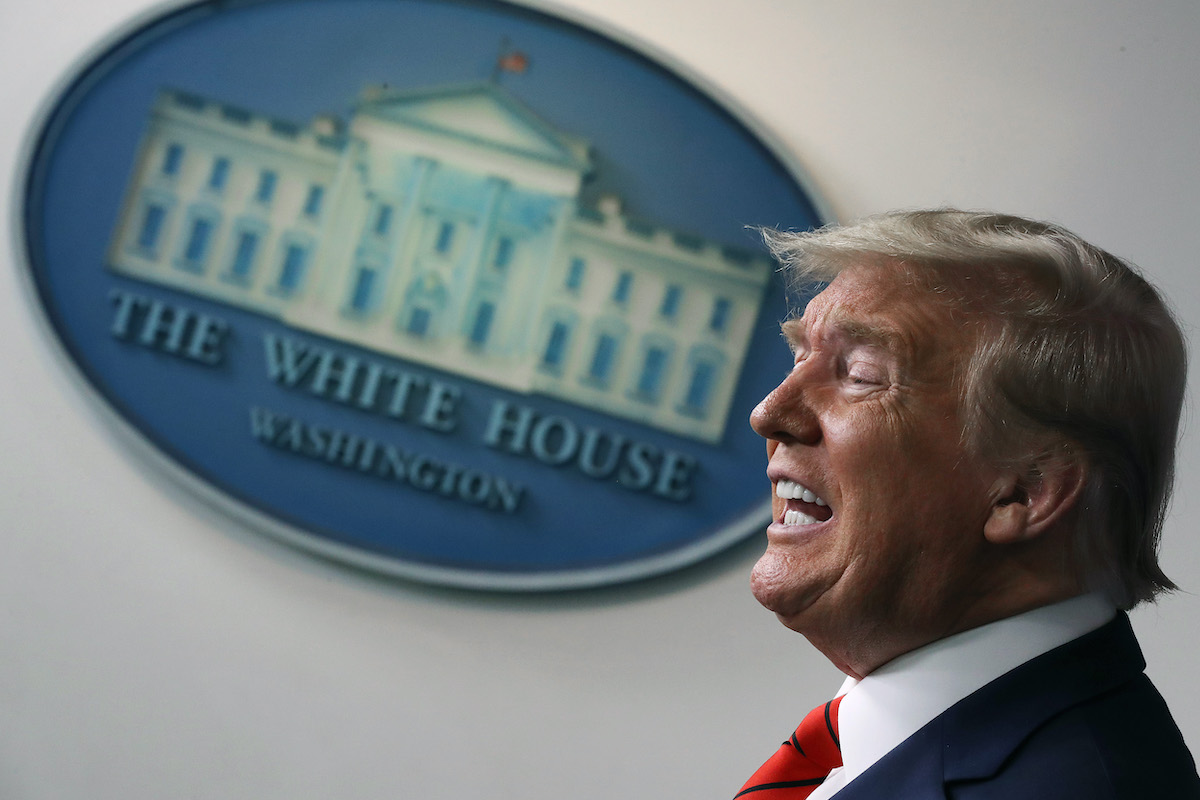 Donald Trump speaks emphatically in front of the white house seal.