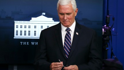 Mike Pence holds up a swab at the daily coronavirus briefing at the White House