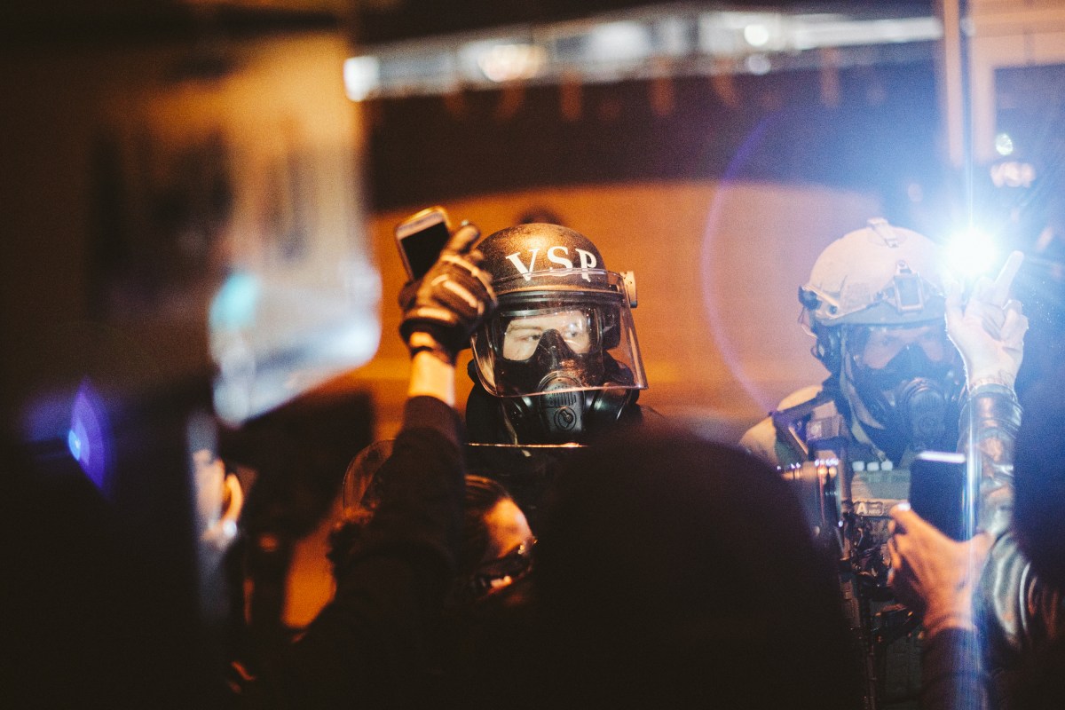 RICHMOND, VA - JUNE 14: Police look on as protesters surround the police head quarters to protest against police brutality, the killing of George Floyd and were calling for the firing of the police officers involved in the hit-and-run of several protesters the night before, on June 14, 2020 in Richmond, United States. George Floyd died on May 25th when he was in Minneapolis police custody, sparking nationwide protests. A white police officer, Derek Chauvin, has been charged with second-degree murder, with the three other officers involved facing other charges. (Photo by Eze Amos/Getty Images)