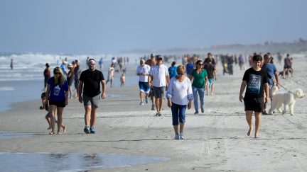 JACKSONVILLE BEACH, FLORIDA - APRIL 17: People are seen at the beach on April 17, 2020 in Jacksonville Beach, Florida. Jacksonville Mayor Lenny Curry announced Thursday that Duval County's beaches would open at 5 p.m. but only for restricted hours and can only be used for swimming, running, surfing, walking, biking, fishing, and taking care of pets. (Photo by Sam Greenwood/Getty Images)