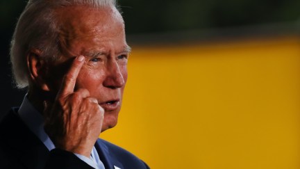 Joe Biden points to his temple while giving a speech.