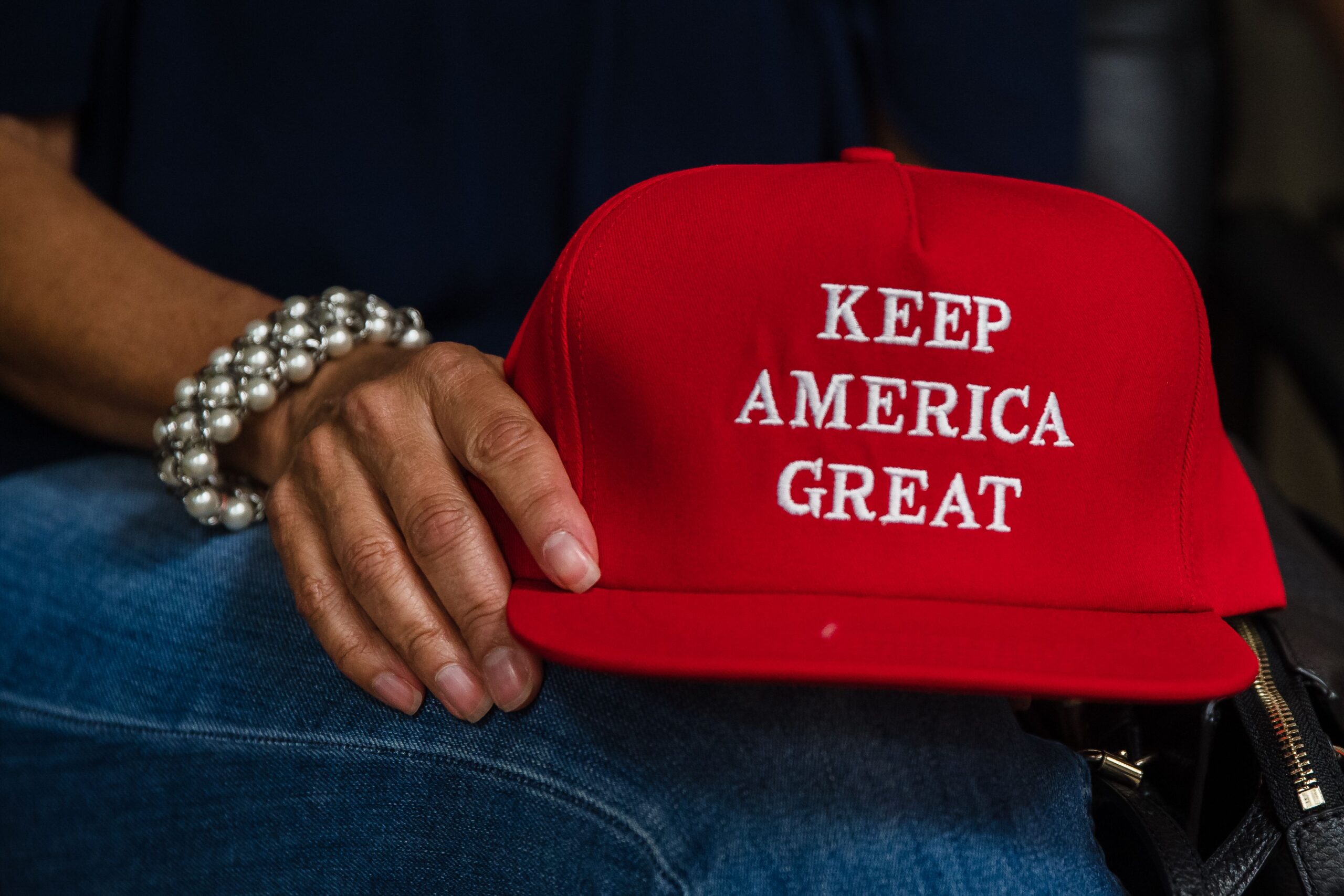 Deborah Palomba holds a "Keep America Great" hat as she watches US President Donald Trump acceptance speech for the Republican Party nomination for reelection during the final day of the Republican National Convention on TV in the office of San Diego County's Republican Party in Rancho Bernardo, California on August 27, 2020. - President Donald Trump tore into his election challenger Joe Biden as a threat to the "American Dream" in a bruising speech August 27 accepting the Republican nomination for a second term against a backdrop of racial tensions and the deadly coronavirus pandemic. (Photo by ARIANA DREHSLER / AFP) (Photo by ARIANA DREHSLER/AFP via Getty Images)