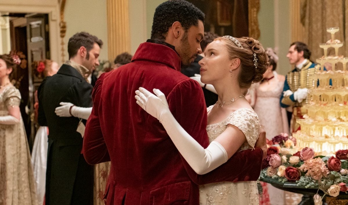 Two people dancing in Regency era clothing at a ball in "Bridgerton"