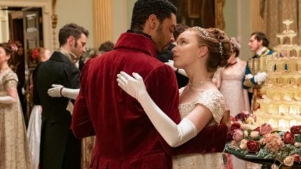 Two people dancing in Regency era clothing at a ball in 