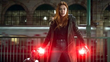 Elizabeth Olsen as Wanda Maximoff/Scarlet Witch fiercely guarding Paul Bettany's Vision with glowing red palms in Marvel's Avengers: Infinity War.