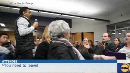 A man hurls a racist comment at another parent during a school meeting about racism.