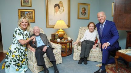 The Bidens and the Carters sitting together, with distorted perspective making the Bidens look giant.