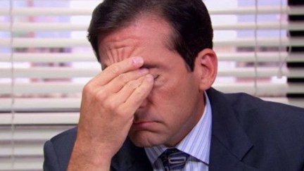 Steve Carell as Michael Scott on the Office, sits at his desk massaging his eyes.