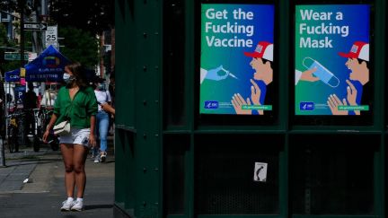 Posters using strong language to warn about Covid-19, bearing the mark of the Department of Health and Human Services (HHS) and the Centers for Disease Control and Prevention (CDC), are on display outside a subway station in New York