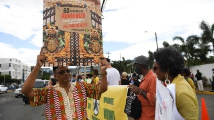 People calling for slavery reparations, protest outside the entrance of the British High Commission during the visit of the Duke and Duchess of Cambridge in Kingston, Jamaica on March 22, 2022. - The Duke and Duchess of Cambridge arrived in Jamaica on Tuesday for a series of outings in honor of Queen Elizabeth's Platinum Jubilee year. (Photo by Ricardo Makyn / AFP) (Photo by RICARDO MAKYN/AFP via Getty Images)