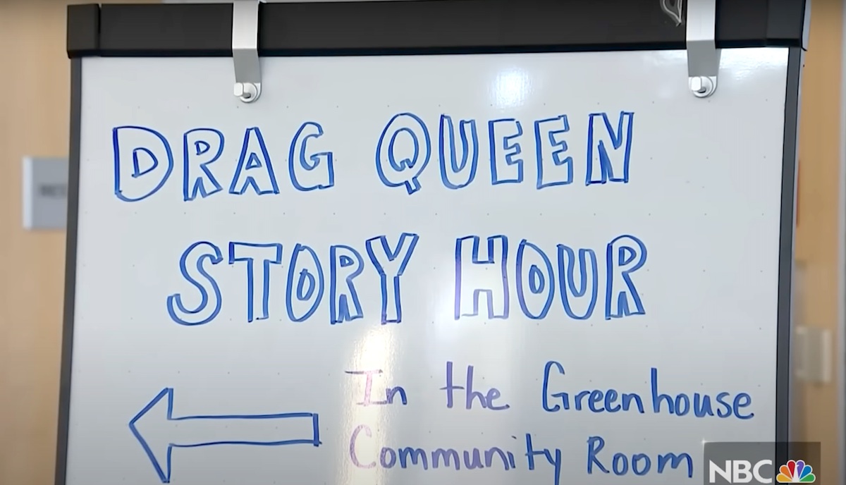 A wipe board reads "drag queen story hour"