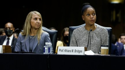 Two witnesses sit at a table in the Senate chamber.