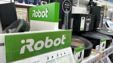 A display of iRobot Roomba vacuums on a store shelf.