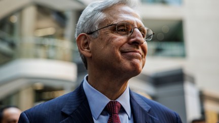 Merrick Garland gives a closed-lipped grin.