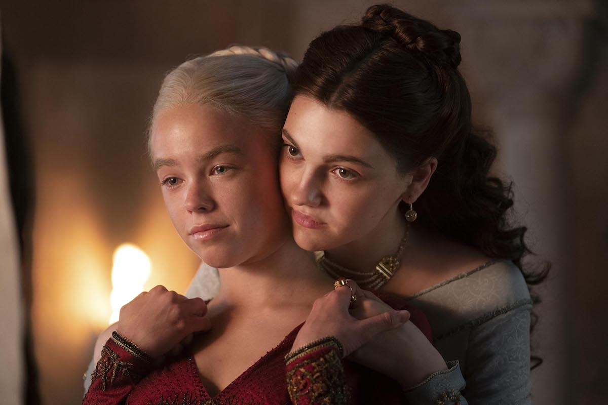 Milly Alcock as Rhaenyra is embraced by Emily Carey as Alicent on House of the Dragon
