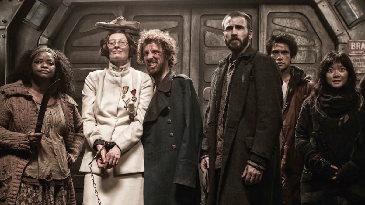 Tilda Swinton is tied up and surrounded by other characters in Snowpiercer.