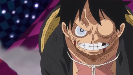 A beaten up Luffy glares furiously at his opponent in 