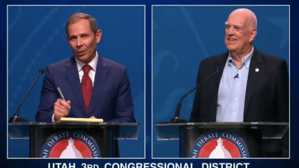 Two white men debate at podiums.