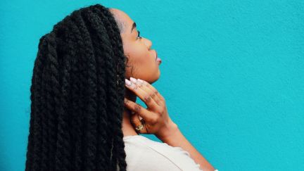 Black woman with long hair looking up.