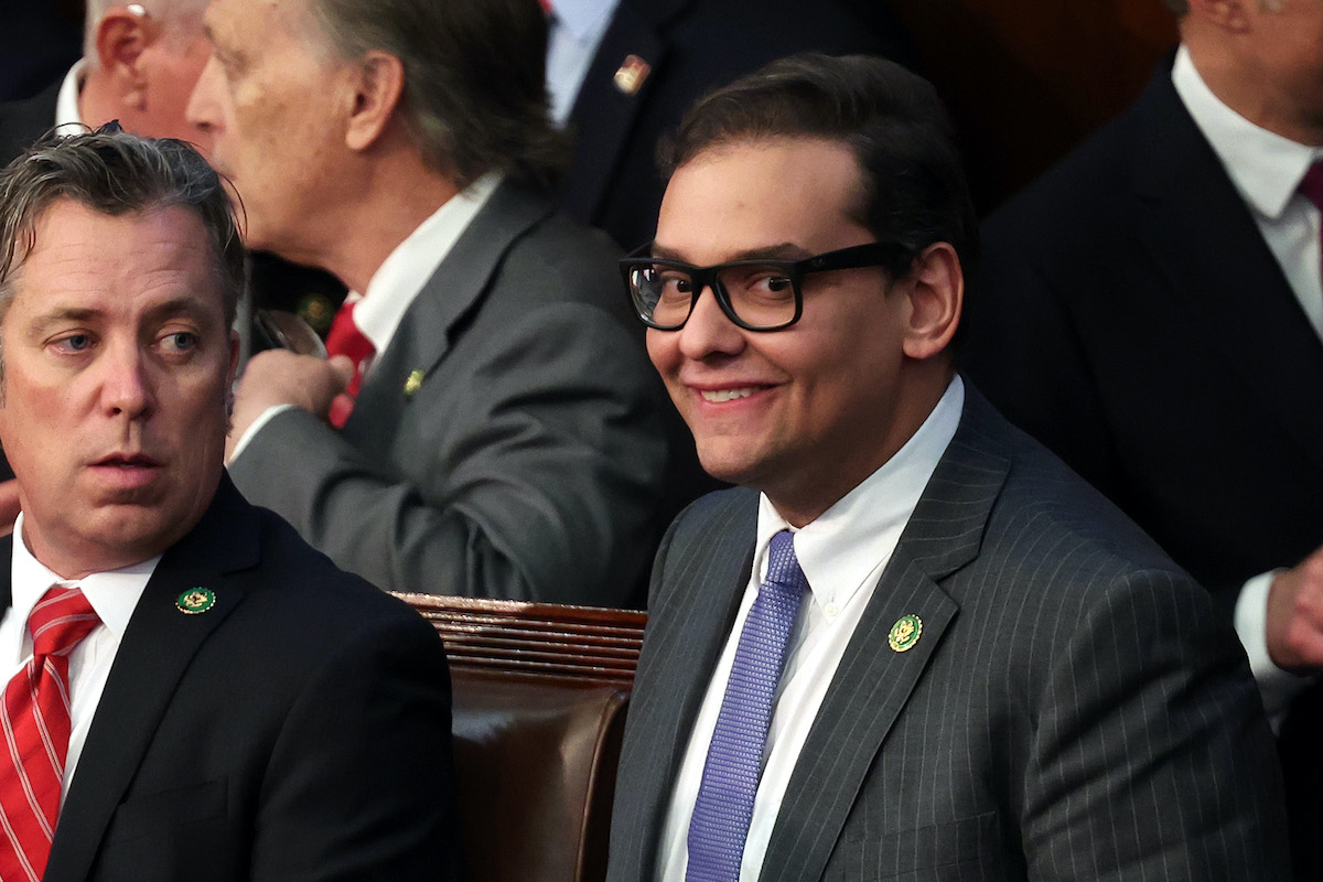 George Santos gives a creepy smile to the camera from the House floor.