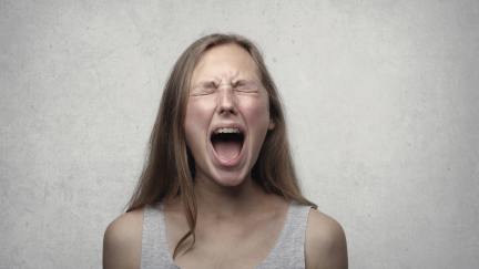 A woman with long blond hair screams.