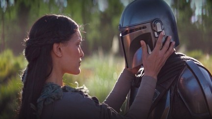 The Mandalorian is about to have his helmet removed by a woman