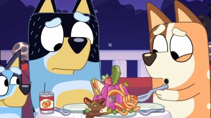 Bandit and Chilli sit at a table, staring in dismay at a disgusting mix of jello and pasta. Bluey stands next to them, smiling.