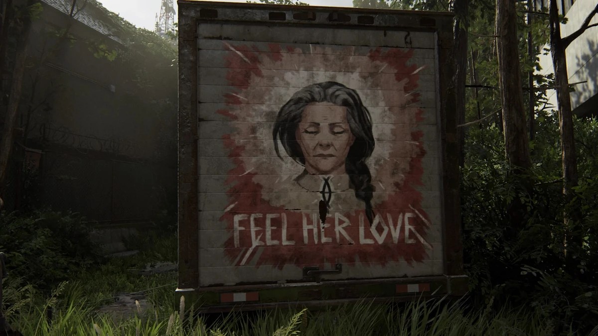 The back of a truck with a mural of a woman that says "feel her love" in The Last of Us Part 2.