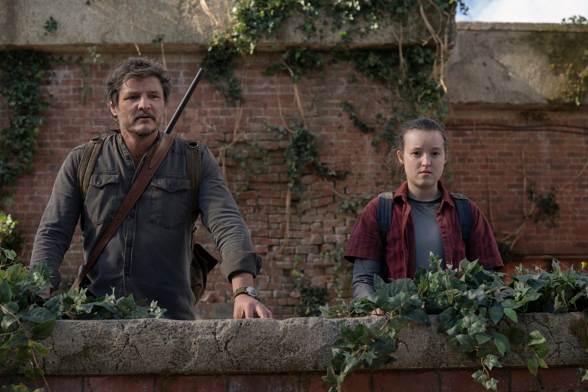 Joel and Ellie look over a low wall.