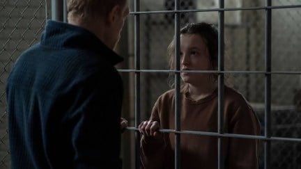 Bella Ramsey as Ellie behind bars in 'The Last of Us' talking to David