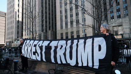 Protesters hold a large banner reading 